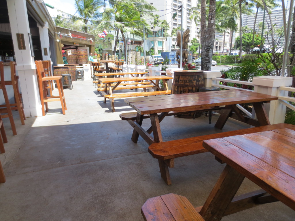 Covered bar seating and picnic table seating are featured at Waikiki Brewing Company.